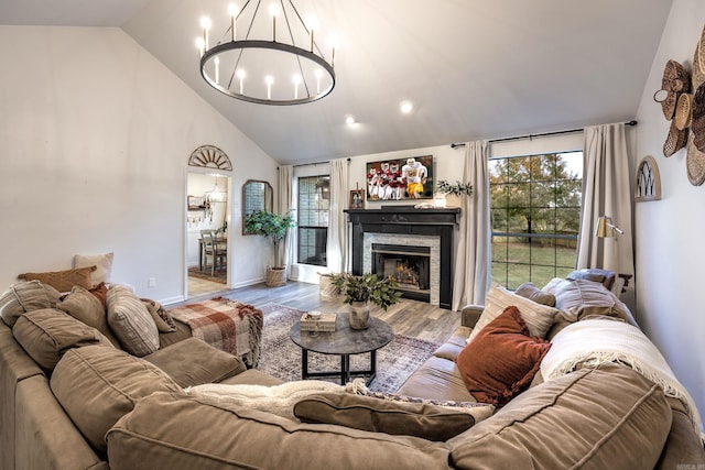 living room with vaulted ceiling, wood-type flooring, and a chandelier