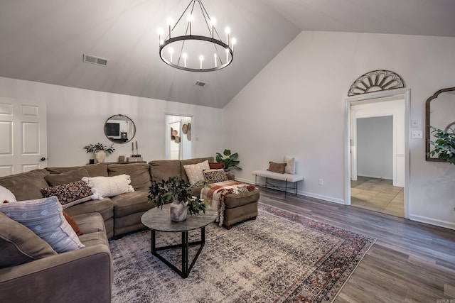 living room with an inviting chandelier, high vaulted ceiling, and hardwood / wood-style flooring