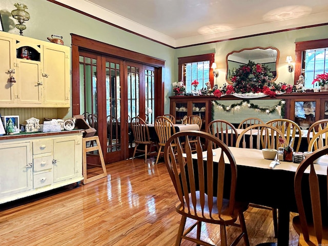 dining area with light wood-type flooring, wine cooler, and crown molding