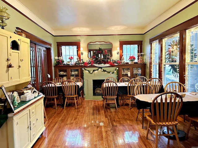 dining area with crown molding and light hardwood / wood-style flooring