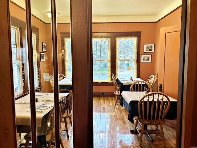 dining space featuring hardwood / wood-style flooring and ornamental molding