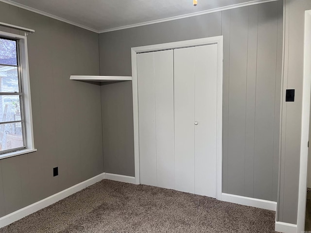 unfurnished bedroom with carpet floors, a closet, and ornamental molding