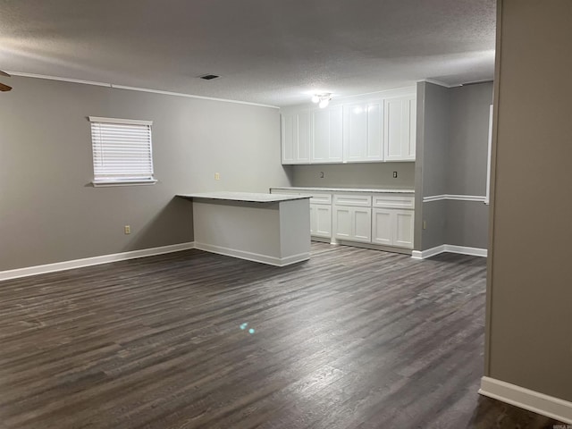 spare room featuring a textured ceiling, crown molding, and dark wood-type flooring