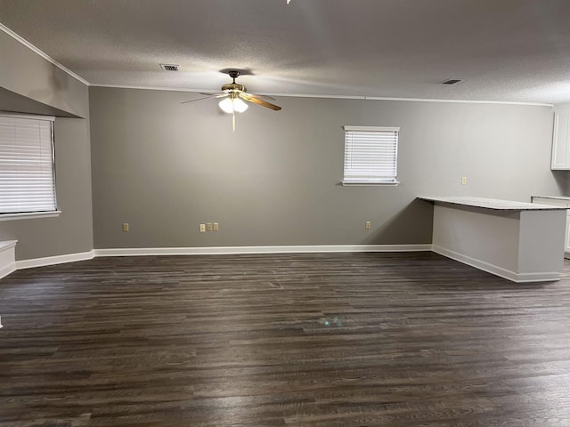 empty room with a textured ceiling, dark hardwood / wood-style flooring, and ceiling fan