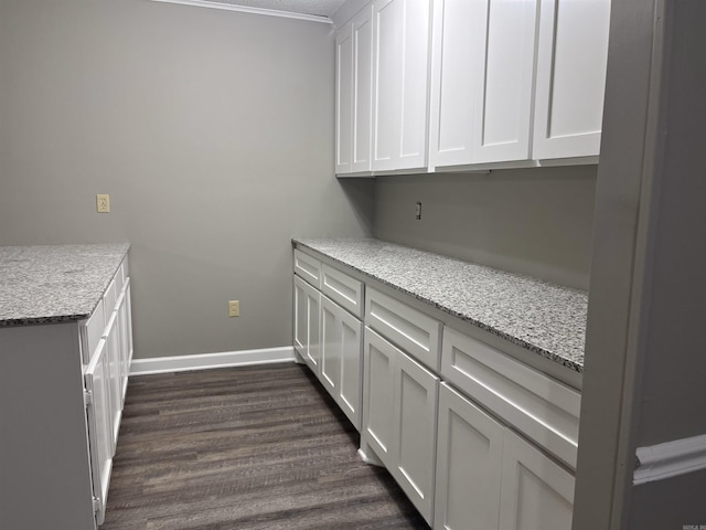 kitchen with white cabinets, light stone countertops, and dark wood-type flooring