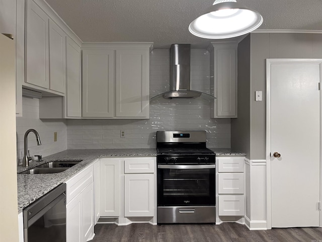 kitchen featuring dark hardwood / wood-style flooring, wall chimney range hood, stainless steel gas stove, black dishwasher, and white cabinetry