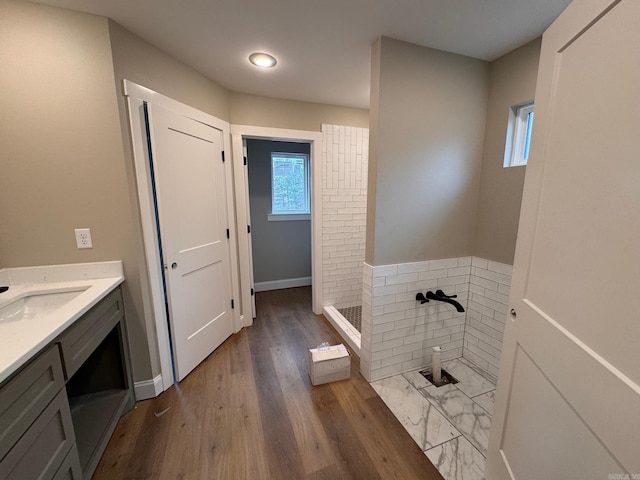 bathroom featuring hardwood / wood-style flooring, a shower, and vanity