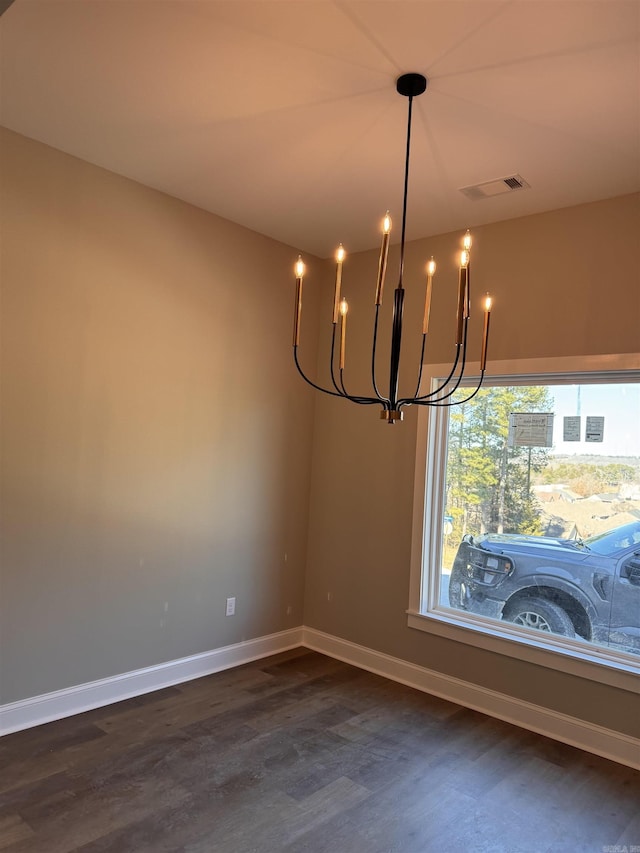 unfurnished dining area with dark hardwood / wood-style floors and a chandelier