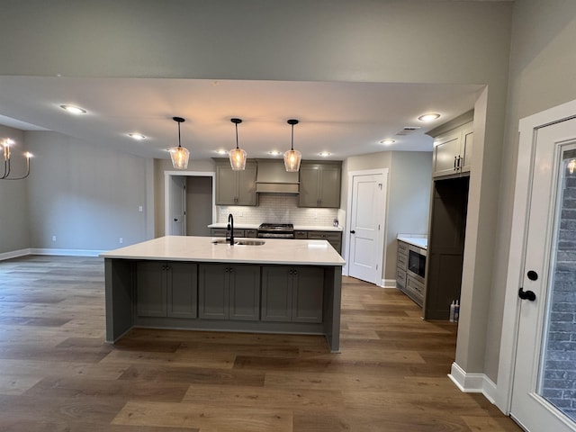 kitchen featuring sink, gray cabinets, an island with sink, pendant lighting, and stainless steel appliances