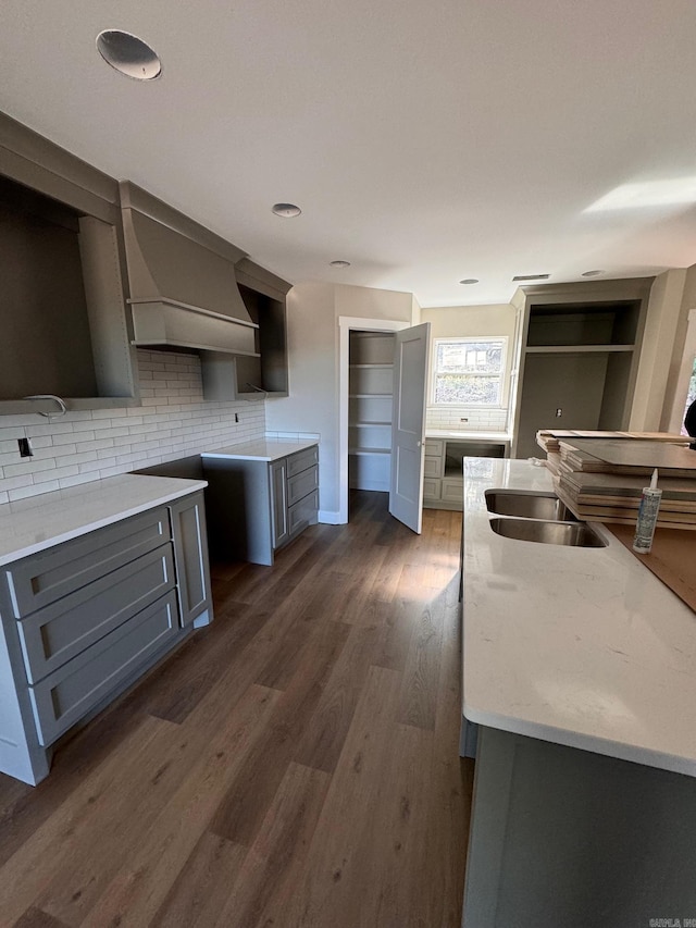 kitchen with backsplash, sink, gray cabinets, and dark hardwood / wood-style floors