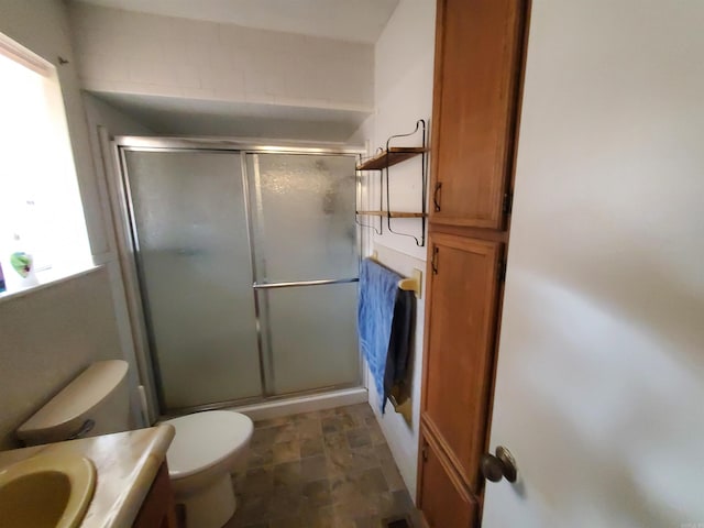 bathroom with vanity, toilet, and a shower with shower door