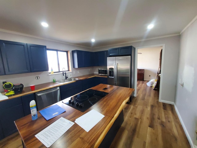 kitchen with hardwood / wood-style floors, blue cabinets, sink, ornamental molding, and stainless steel appliances