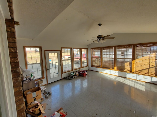 interior space with ceiling fan, a textured ceiling, and vaulted ceiling