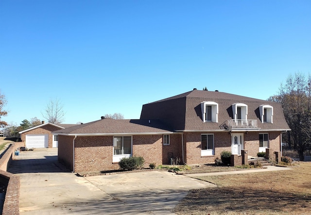 view of front of property with a balcony, a garage, and an outdoor structure