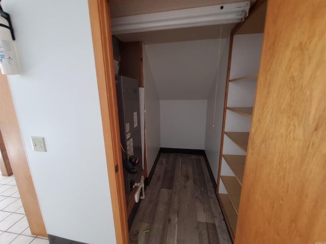 corridor with wood-type flooring and heating unit