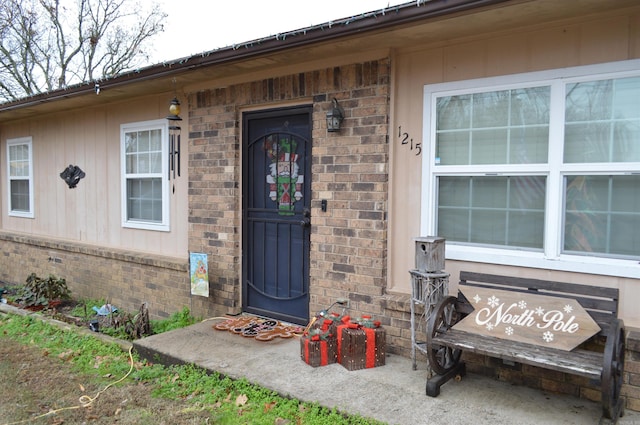 view of exterior entry with brick siding