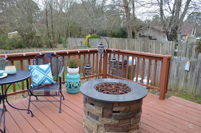 wooden terrace with fence and a fire pit