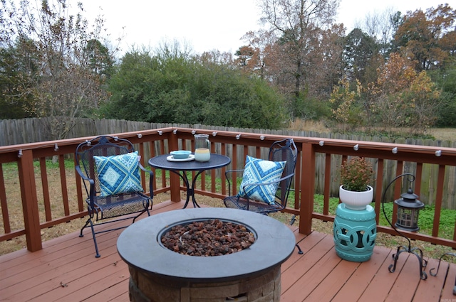 wooden deck with a fire pit and fence