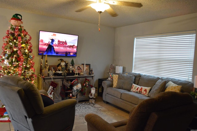 living room featuring tile patterned flooring, a ceiling fan, and a textured ceiling