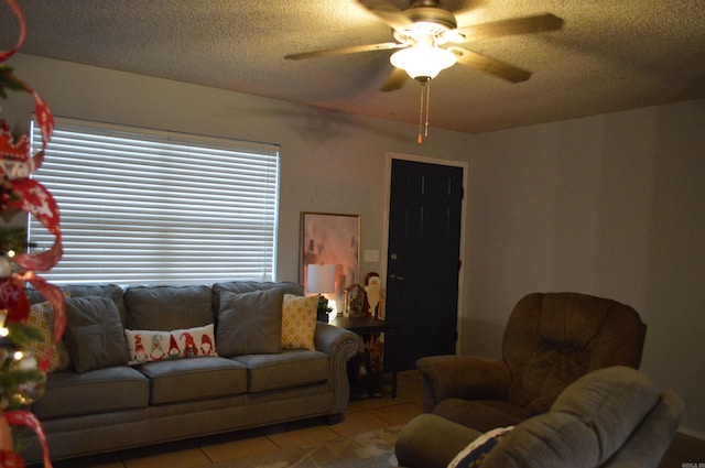 living room featuring light tile patterned floors, a textured ceiling, and a ceiling fan