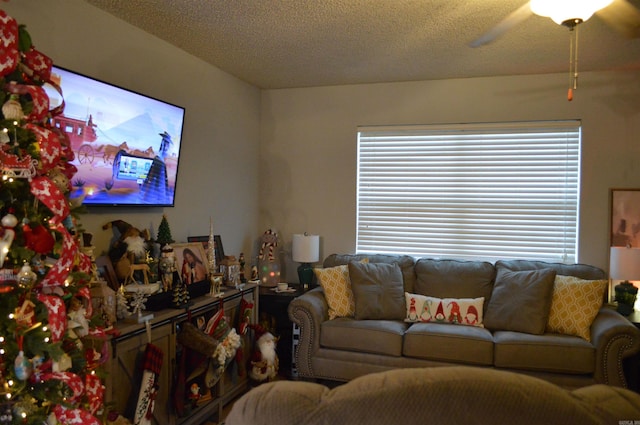 living room with ceiling fan and a textured ceiling