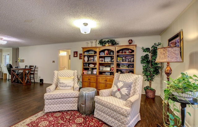 sitting room with a textured ceiling and dark hardwood / wood-style floors