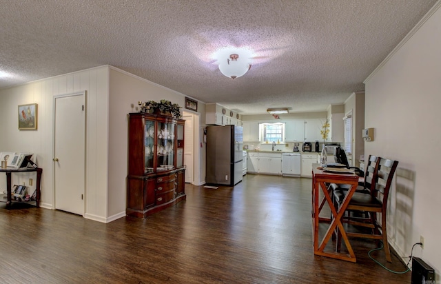 dining room with ornamental molding, a textured ceiling, dark wood-type flooring, and sink