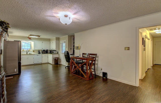 dining area with a textured ceiling, dark hardwood / wood-style floors, crown molding, and sink