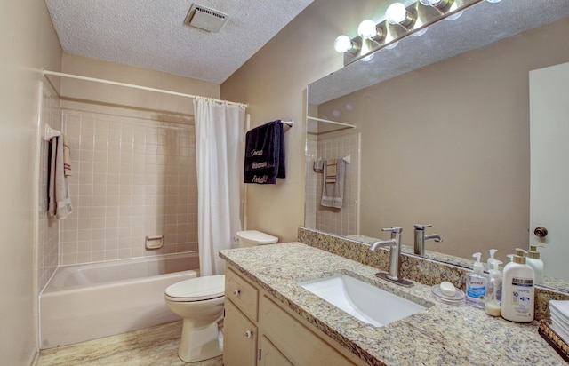 full bathroom featuring shower / tub combo with curtain, vanity, a textured ceiling, and toilet