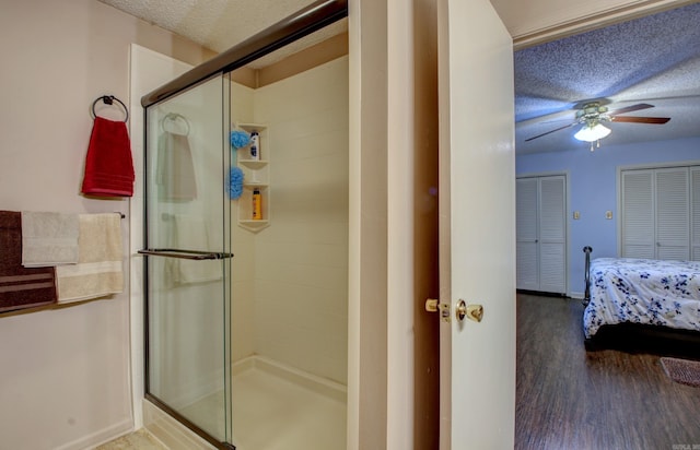 bathroom featuring an enclosed shower, a textured ceiling, hardwood / wood-style flooring, and ceiling fan