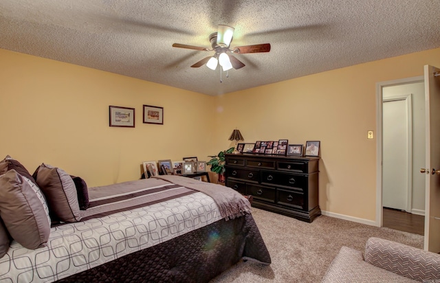 carpeted bedroom featuring ceiling fan and a textured ceiling