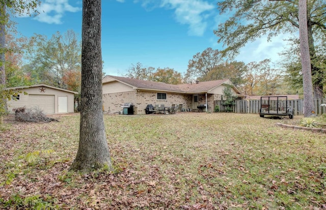 view of yard featuring central AC, a trampoline, a garage, and an outdoor structure