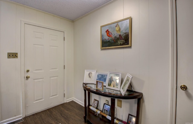 foyer featuring a textured ceiling, dark hardwood / wood-style flooring, and ornamental molding