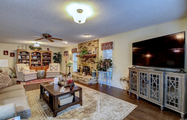 living room with ceiling fan, a fireplace, a textured ceiling, and hardwood / wood-style flooring