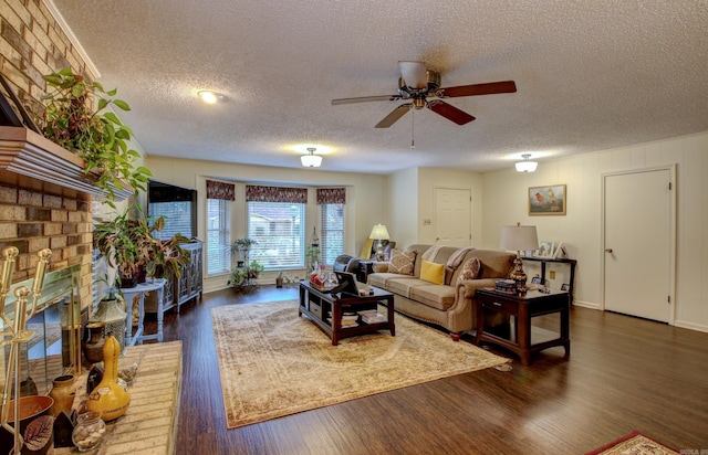 living room featuring a fireplace, a textured ceiling, dark hardwood / wood-style flooring, and ceiling fan