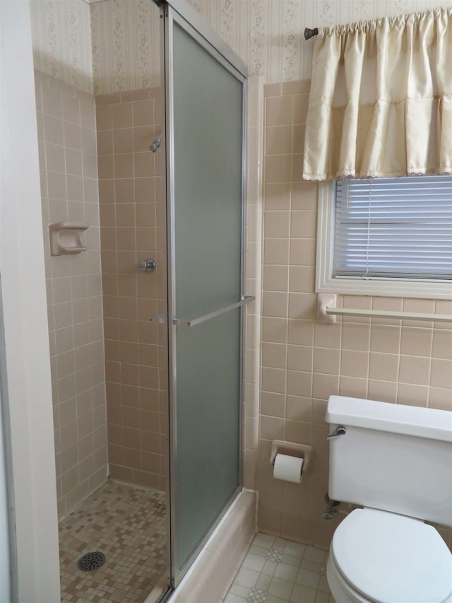 bathroom with tile patterned flooring, an enclosed shower, and toilet