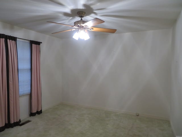 spare room with ceiling fan and light colored carpet