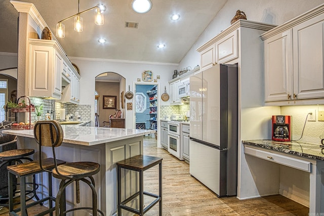 kitchen featuring kitchen peninsula, a kitchen breakfast bar, light wood-type flooring, stainless steel appliances, and crown molding