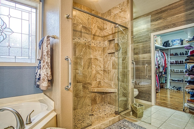 bathroom with separate shower and tub, a wealth of natural light, tile patterned floors, and a textured ceiling