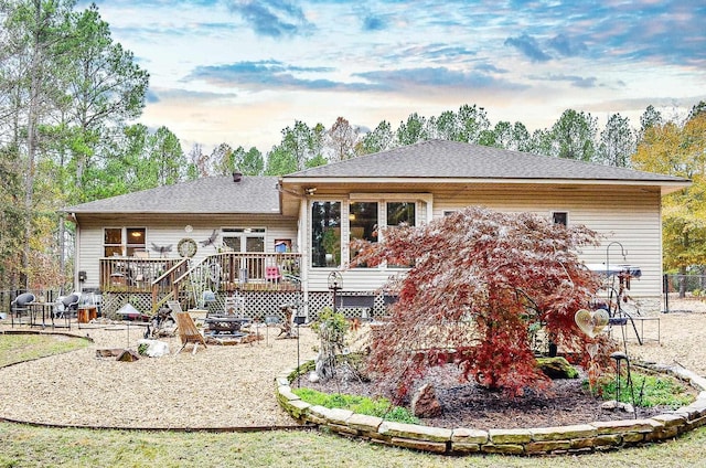 back of house with a wooden deck and an outdoor fire pit