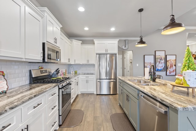 kitchen featuring pendant lighting, light hardwood / wood-style floors, white cabinetry, and stainless steel appliances