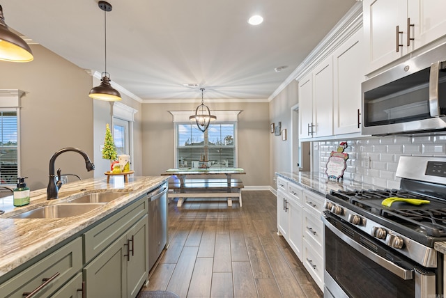 kitchen with decorative light fixtures, dark hardwood / wood-style flooring, sink, and stainless steel appliances