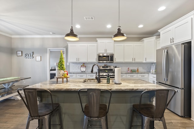 kitchen featuring light hardwood / wood-style floors, white cabinetry, pendant lighting, and appliances with stainless steel finishes