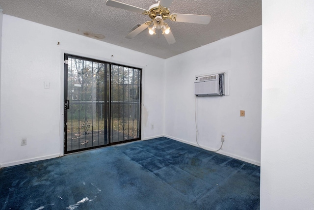 empty room featuring dark colored carpet, a textured ceiling, a wall unit AC, and ceiling fan