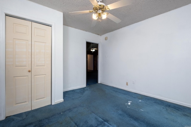 unfurnished bedroom featuring a textured ceiling, dark carpet, a closet, and ceiling fan