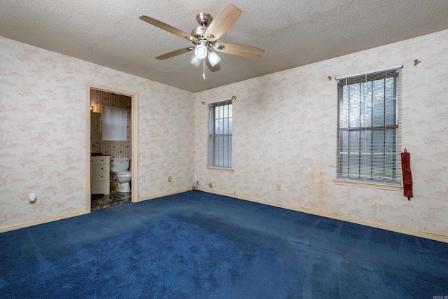 carpeted spare room with ceiling fan and a textured ceiling