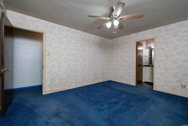 carpeted spare room featuring ceiling fan and a textured ceiling