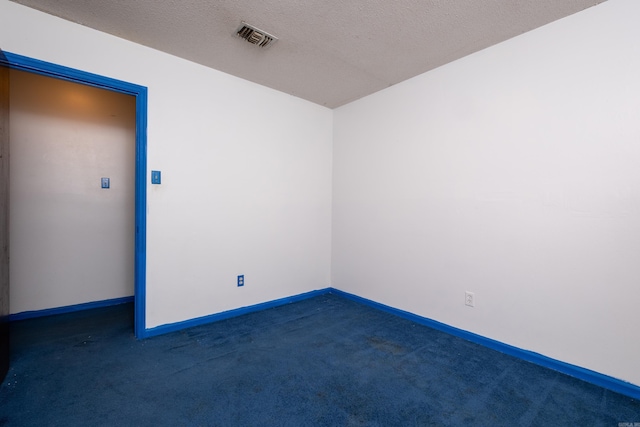 carpeted empty room featuring a textured ceiling