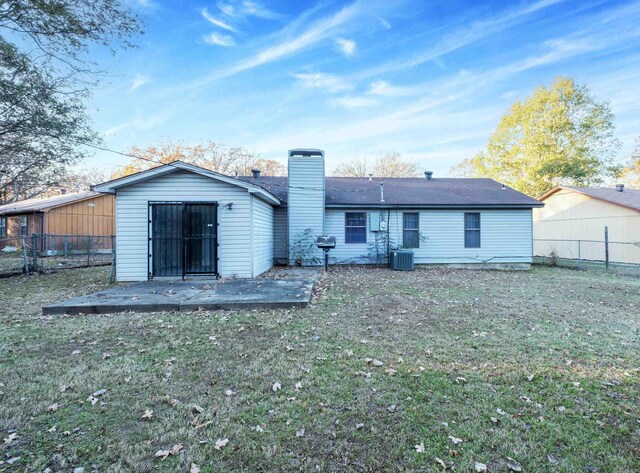 back of property featuring a lawn, central air condition unit, and a patio