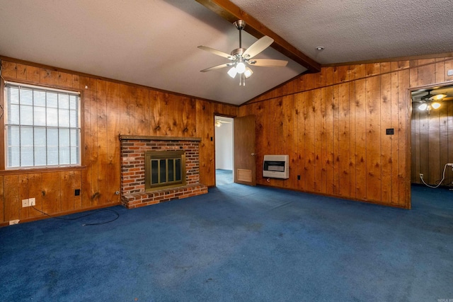 unfurnished living room with heating unit, wood walls, a fireplace, and dark colored carpet